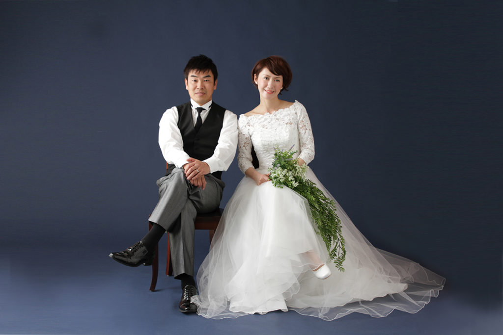 ウエディングドレスとベストで座っている結婚20周年のご夫婦