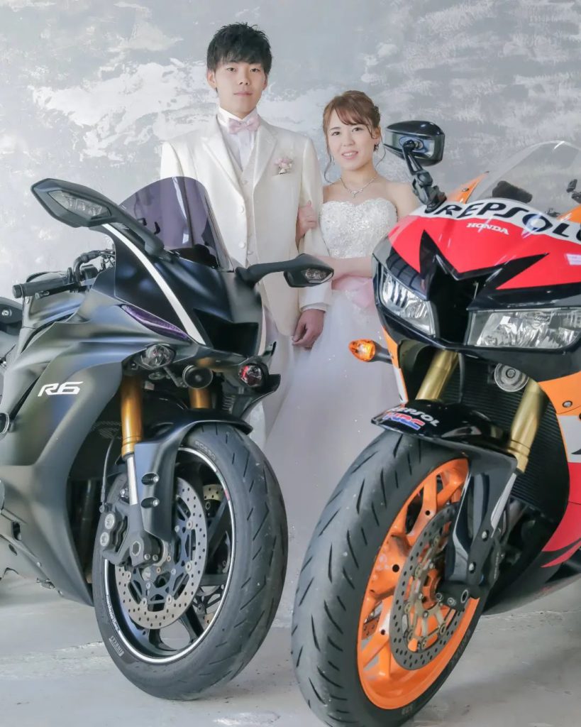 スタジオで腕を組む新郎新婦様の前にお二人の愛車