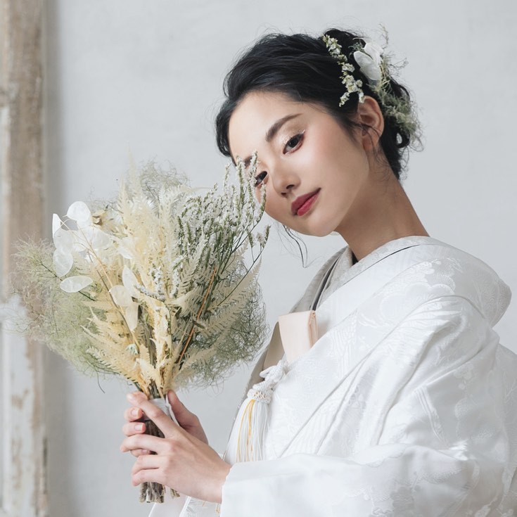 ブーケやヘアアクセサリーなども白系でまとめた白無垢花嫁さま。