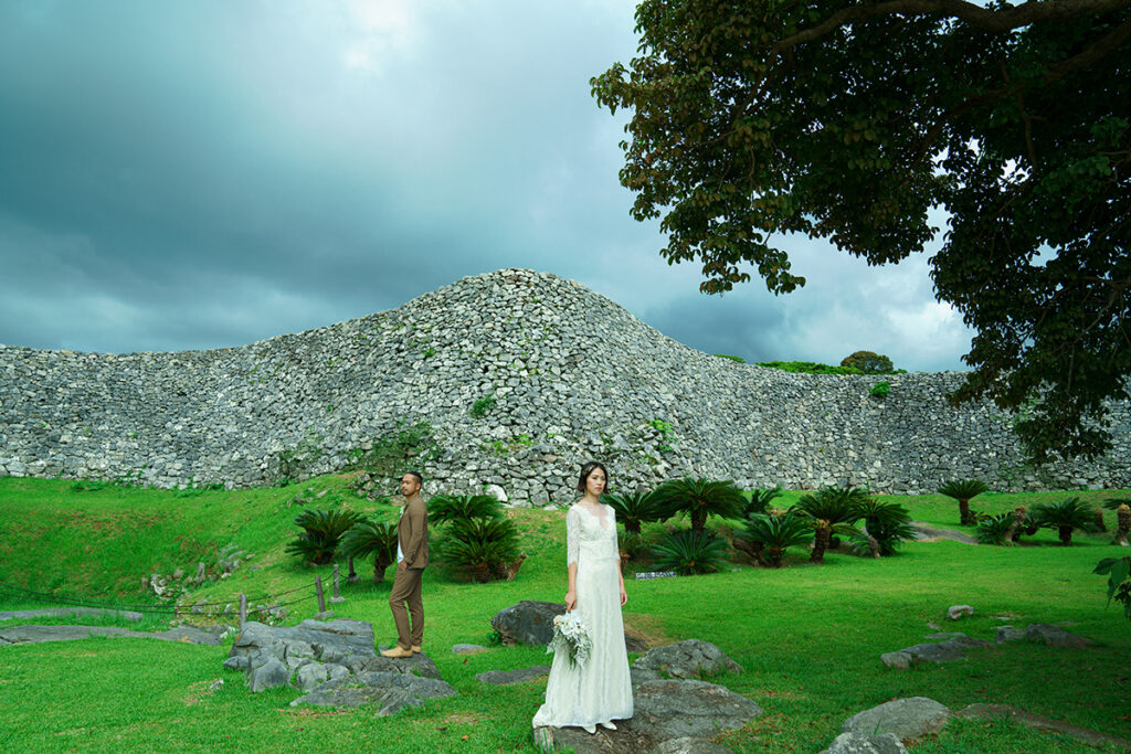 世界遺産、今帰仁城（なきじんじょう）の石垣を背景にした新郎新婦