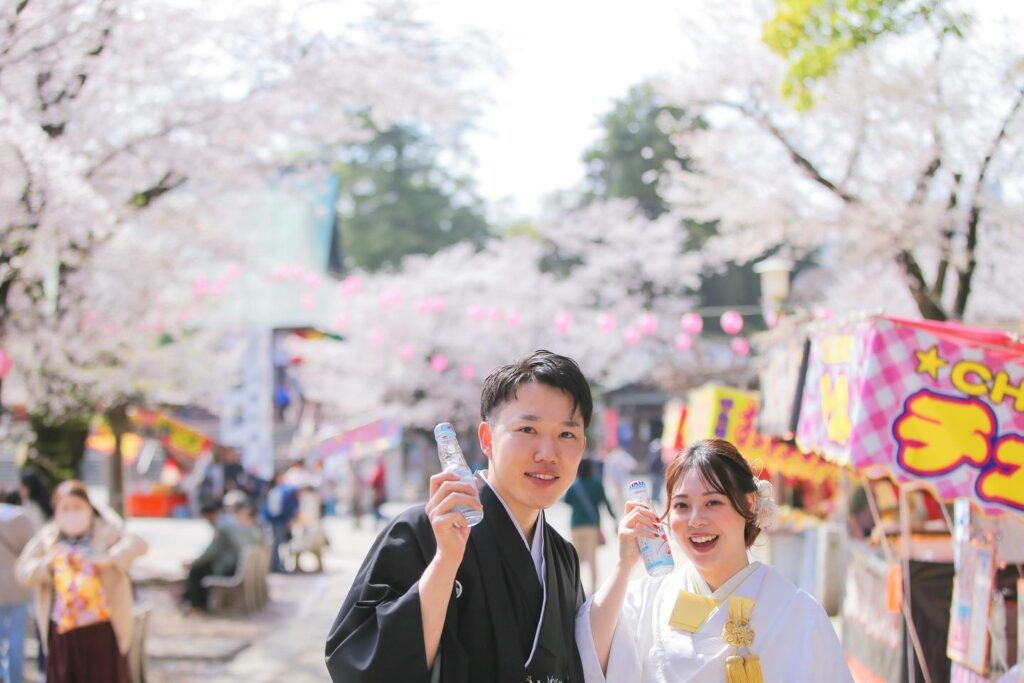 桜ロケーション撮影、ラムネ片手に笑顔の新郎新婦