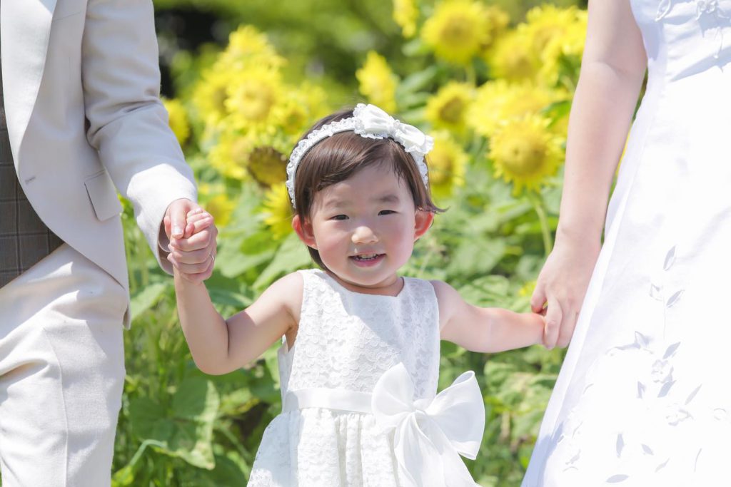 新郎新婦の間に、お子様を挟んで手つなぎ、お子様メインの写真